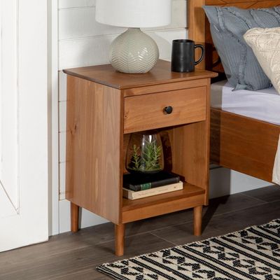 Walker Edison Traditional Wood Nightstand placed beside a bed in a cozy bedroom, styled with a lamp and decorative items.