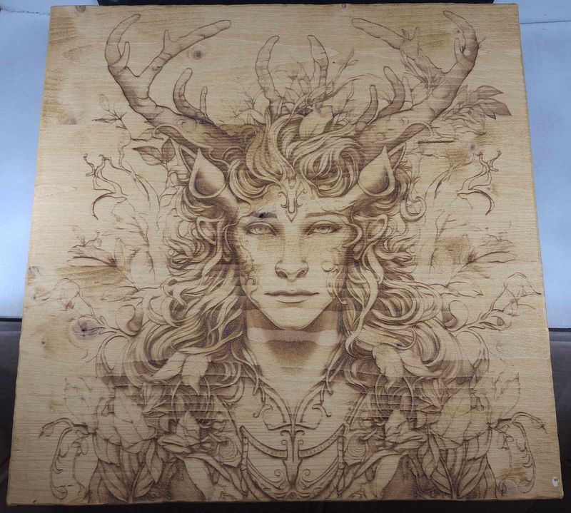Pyrogravure laser d'un homme cerf sur bois