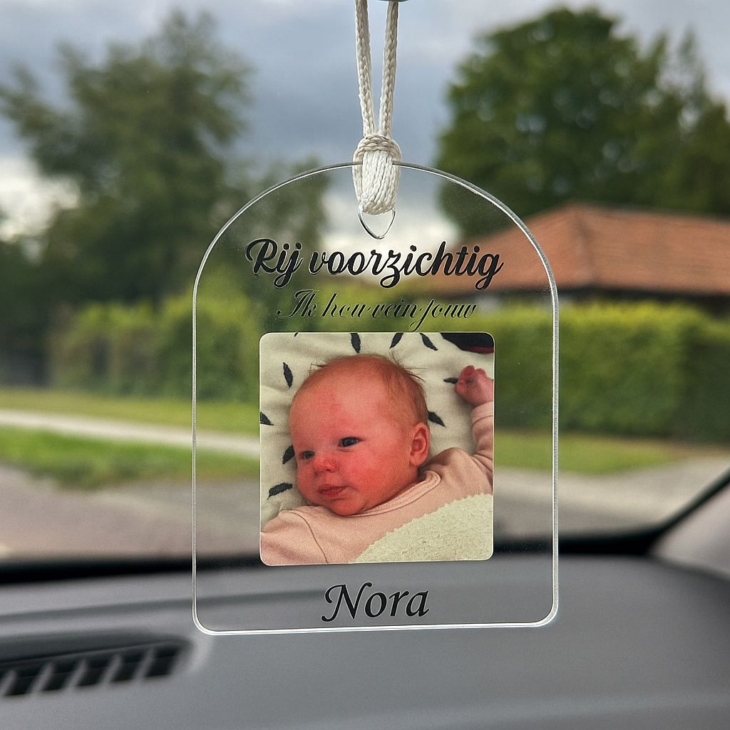 Close-up autohanger met foto en tekst, toont hoogwaardige bedrukking en transparant materiaal.