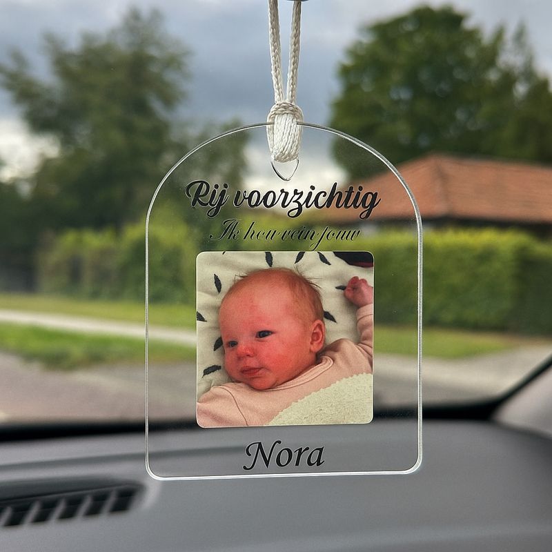 Close-up autohanger met foto en tekst, toont hoogwaardige bedrukking en transparant materiaal.