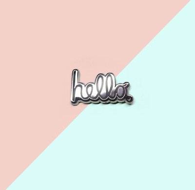 A enamel pin with the classic Hello graphic design from the famous advertising campaign for the classic computer. 