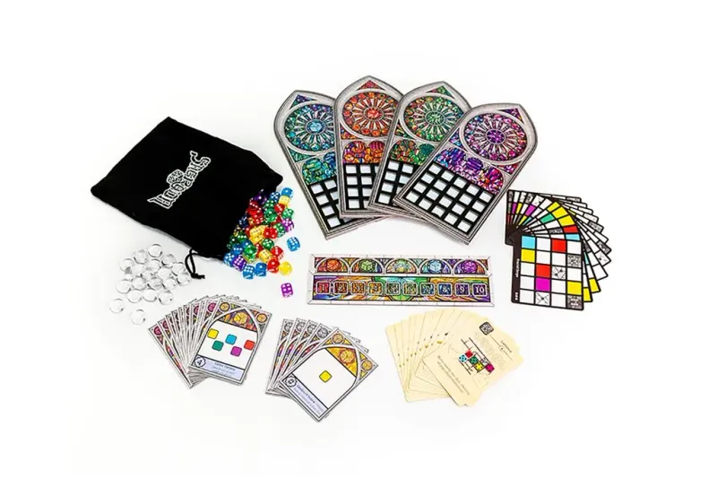 Sagrada board game components, including stained glass window pieces, colorful dice, cards, and bag, laid out on a white background.
