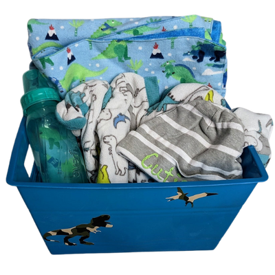 Handmade baby gift bundle with dinosaur theme including sleeper, hat, blanket, and bottle