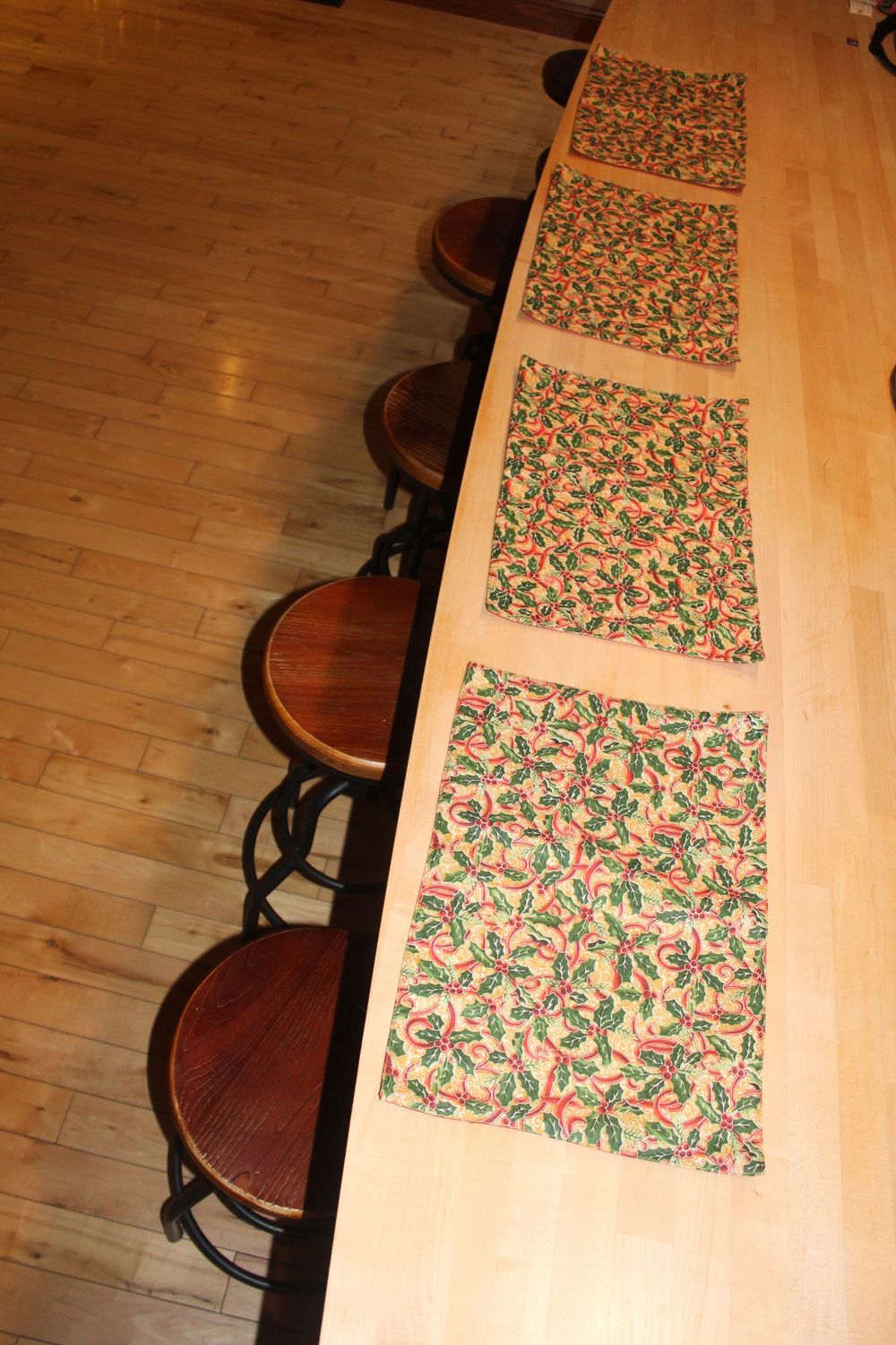 Festive holiday placemats set with red backing and holly design