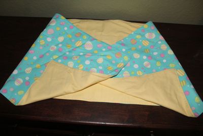 Handmade reversible Easter table runner with pastel egg pattern and yellow backing.