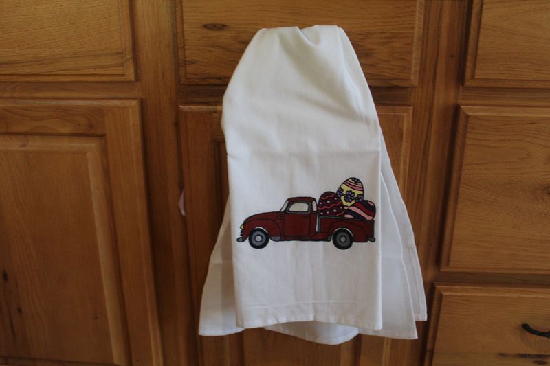 Hand painted Easter truck kitchen towel with vintage red pickup carrying colorful Easter eggs.