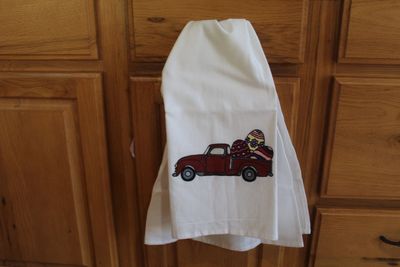 Hand painted Easter truck kitchen towel with vintage red pickup carrying colorful Easter eggs.