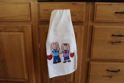 Easter bunny couple dish towel with hand painted rabbits holding hearts.