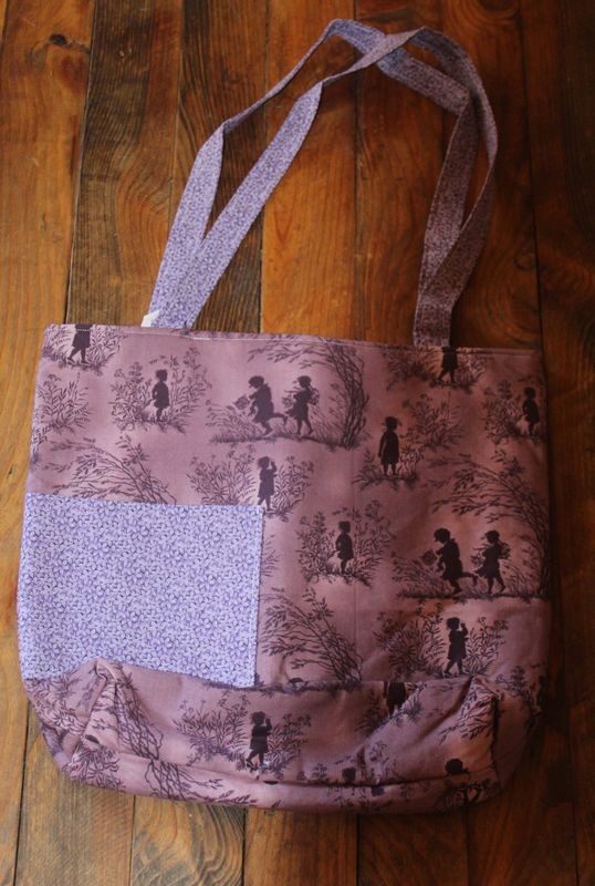 Handmade mauve vintage silhouette tote bag with floral pocket on wood table.