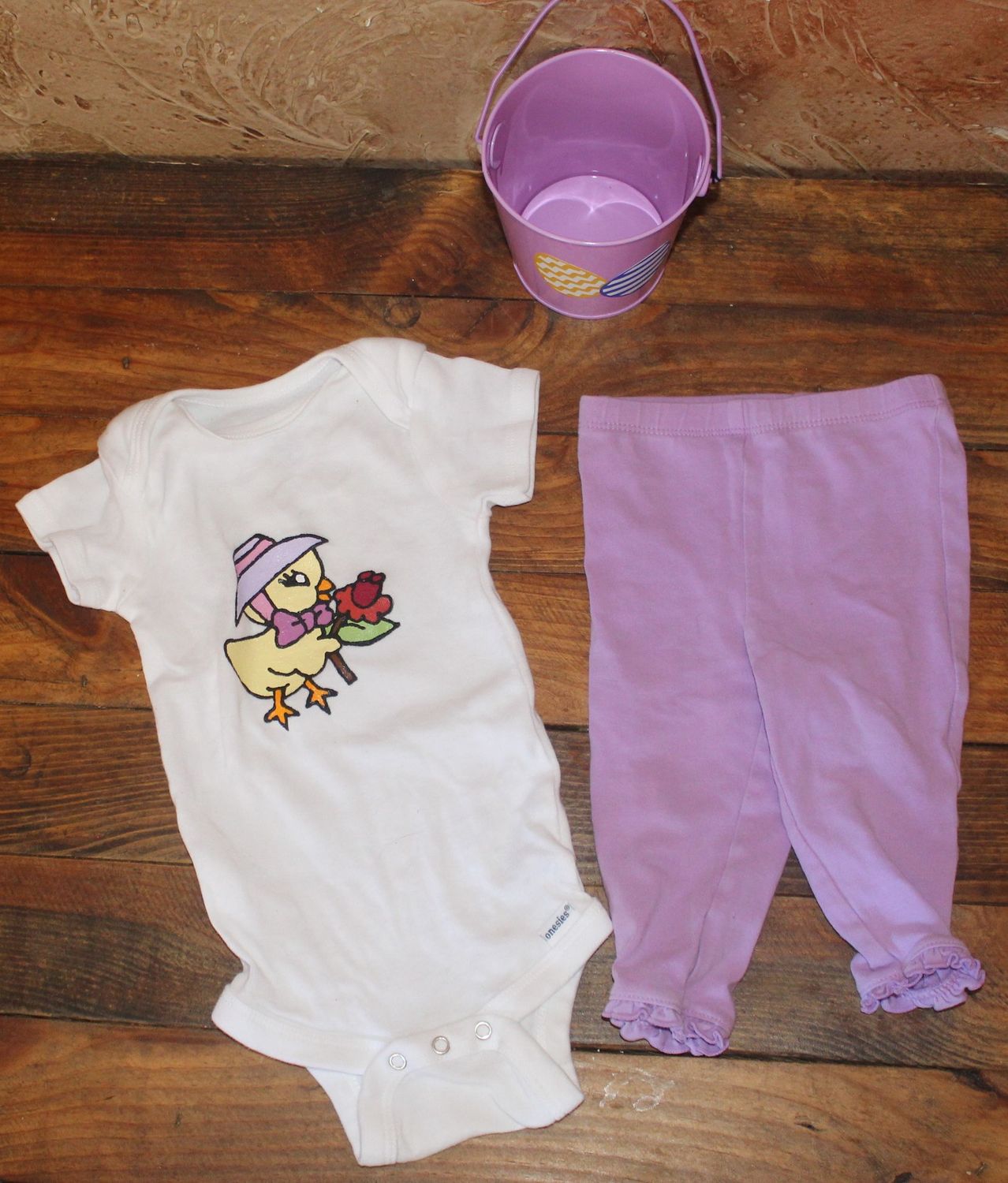 Hand painted Easter Baby Gift Basket – Bunny Outfit & Cozy Essentials | Perfect Easter Baby Shower Gift Hand painted baby Easter outfit with chick applique onesie, purple leggings, and decorative bucket