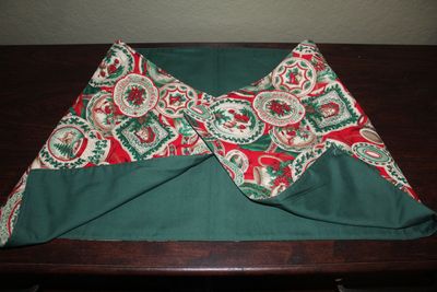 Handmade reversible Christmas table runner with red and green poinsettia and Santa holiday pattern