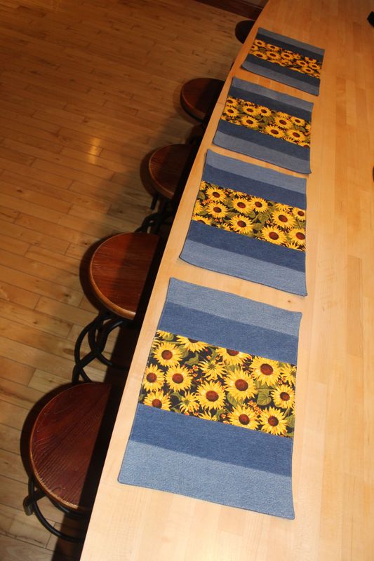 Handmade sunflower placemats set of 4 with denim panels displayed on wooden kitchen island