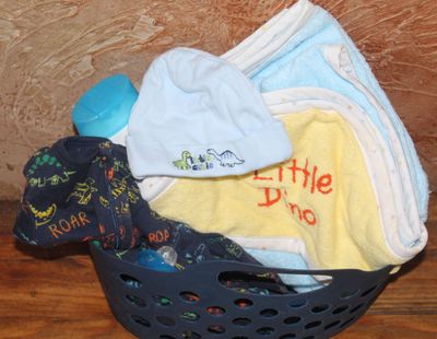 Dinosaur baby gift basket for boys with hooded towel, hat, and pajamas