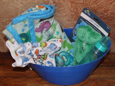 Dinosaur-themed baby gift set with plush toy, teething ring, bottle, and custom onesie