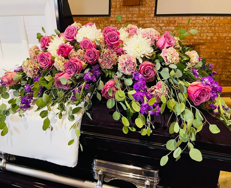 Feminine casket piece with seasonal greens