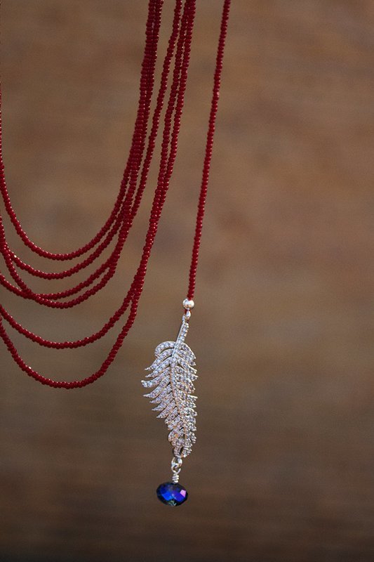 Gold finished rhinestone feather with garnet, red seed bead strands, sterling silver clasp