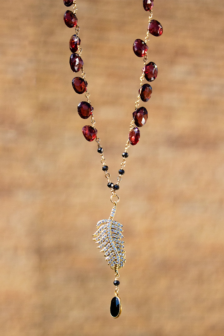 Gold finished rhinestone feather, garnet beads, 14kt gold-filled chain and clasp