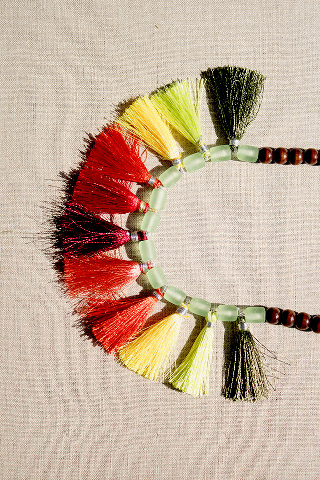 Necklace with large multi-colored tassels and wooden beads