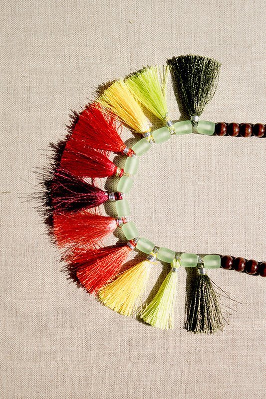 Necklace with large multi-colored tassels and wooden beads