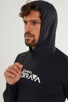 Man wearing Johnn Brava black hooded lycra top with UV protection while surfing