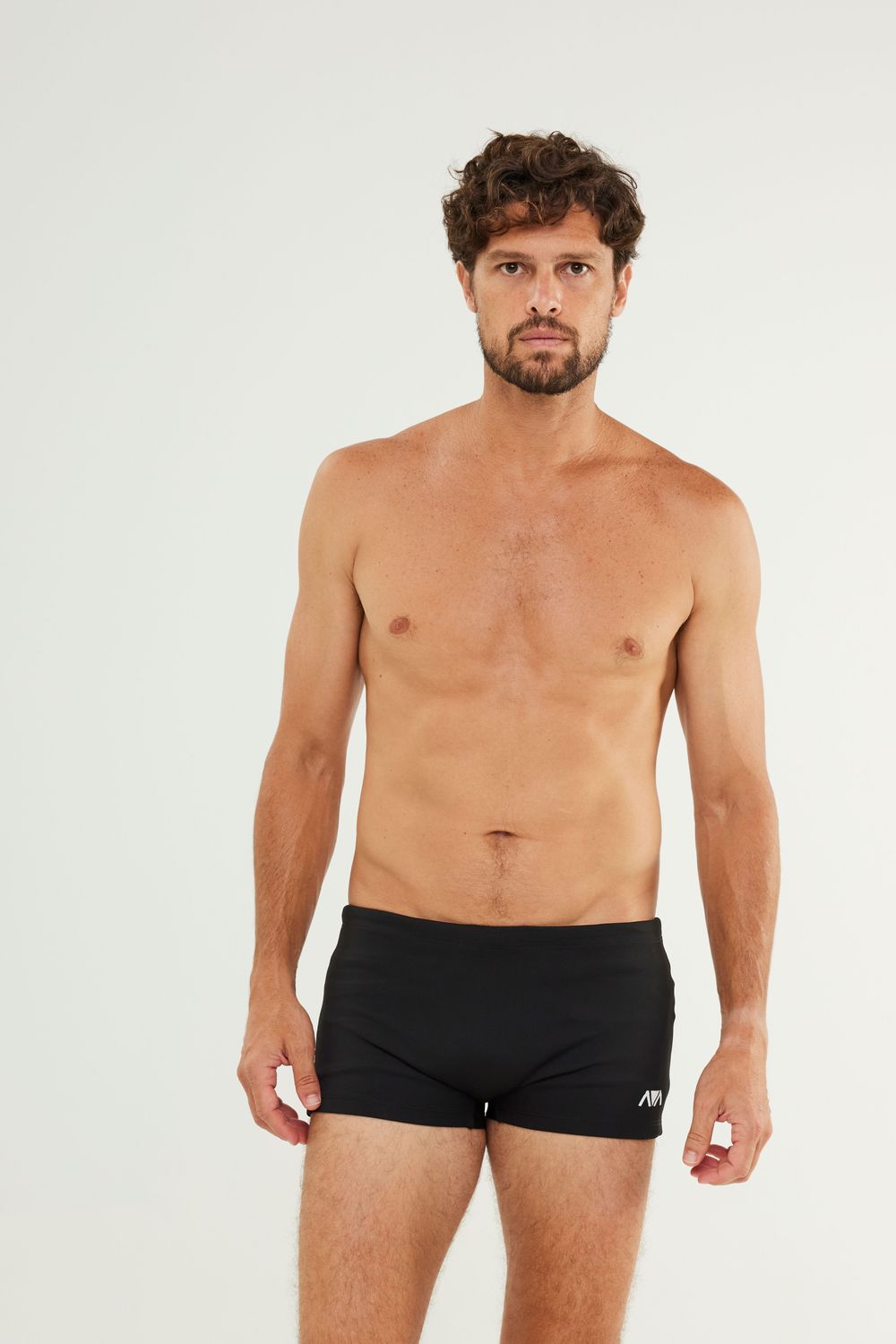 Man wearing Johnn Brava neo slim swim trunks at the beach