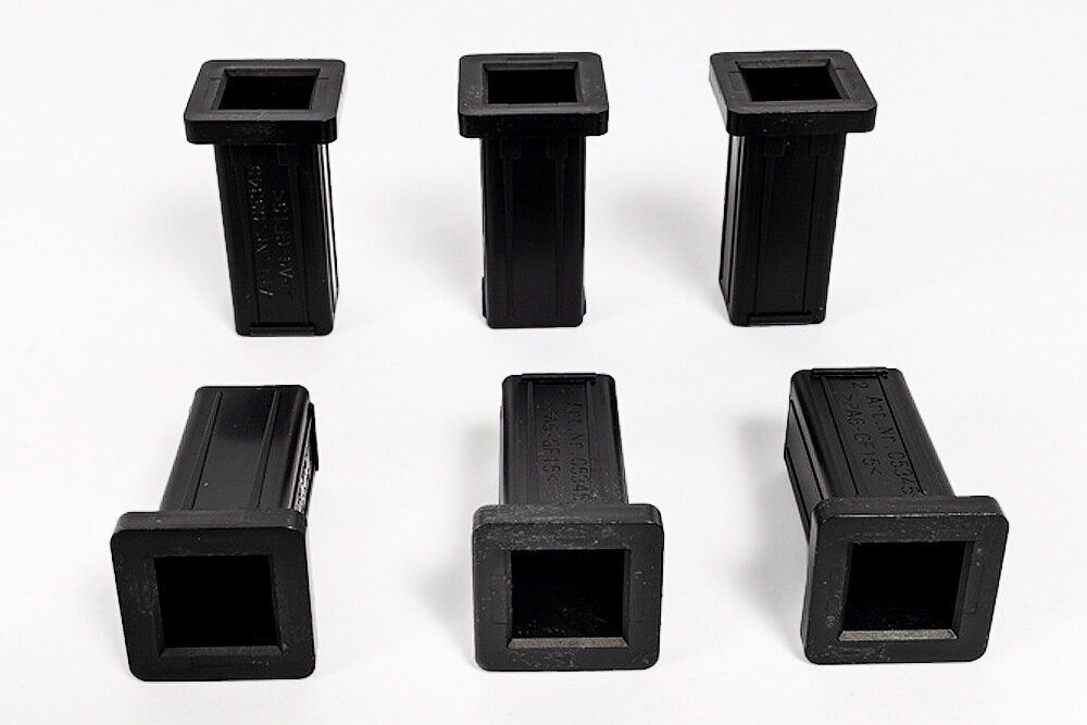 sechs schwarze Kunststoff Sitzbuchsen in quadratischer Form mit leicht erhabener Mitte