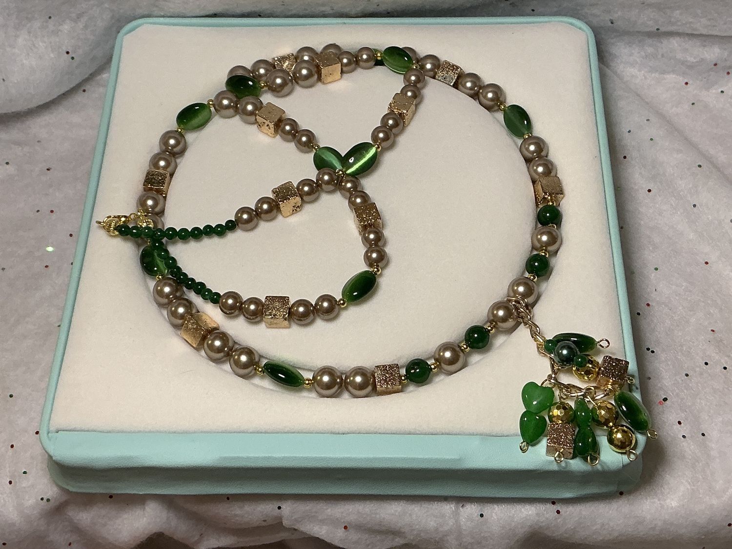 Golden pearls with gold, lava squares, and emerald green cat eyes