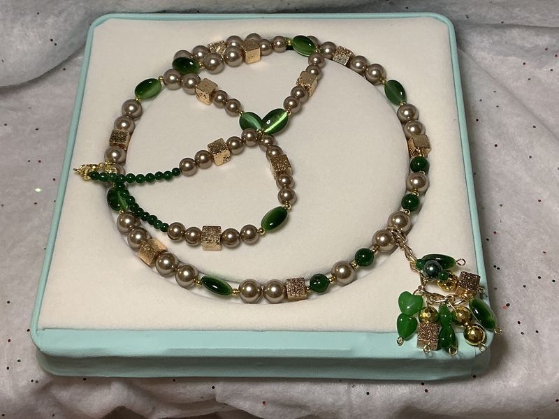 Golden pearls with gold, lava squares, and emerald green cat eyes