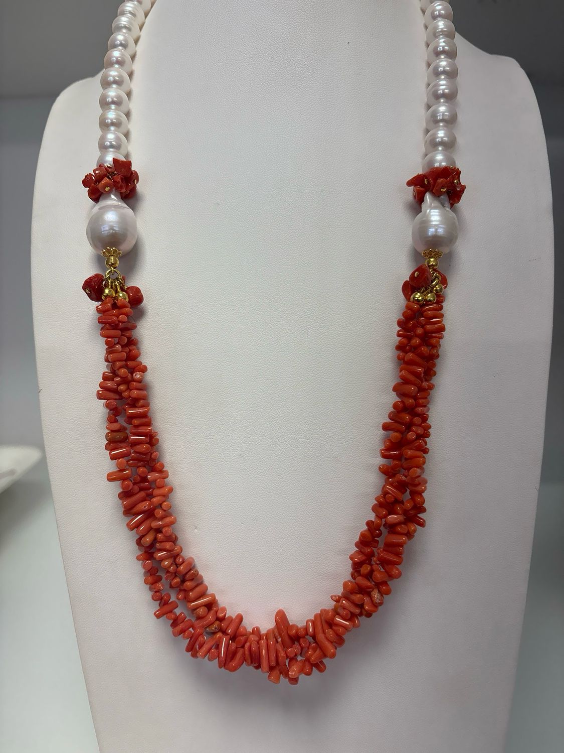 Collana lunga 60 cm con perle di coltivazione di acqua dolce millimetri 10 e due Scaramazze, impreziosita da tre fili di corallo mediterraneo, con chiusura in argento 925 placcato oro.