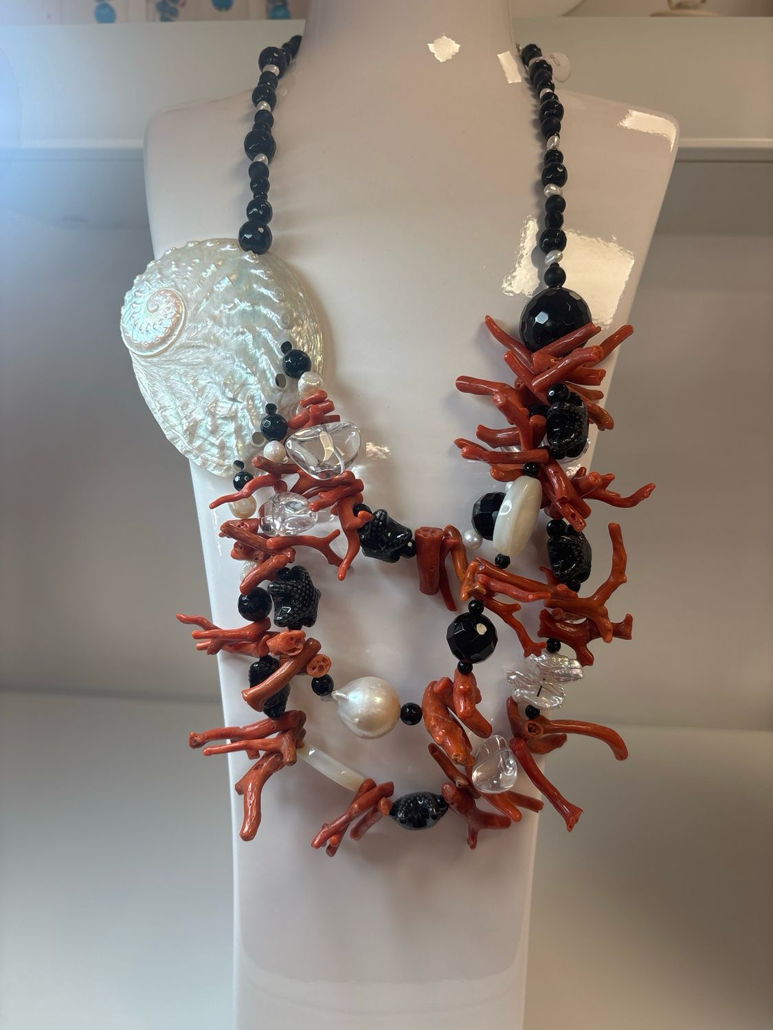 Collana di circa 60 cm con Agata nera sfaccettate ,perle di fiume,  perla barocca,madreperla ,cristallo di rocca e centrale di vera conchiglia.con chiusura in argento 925.