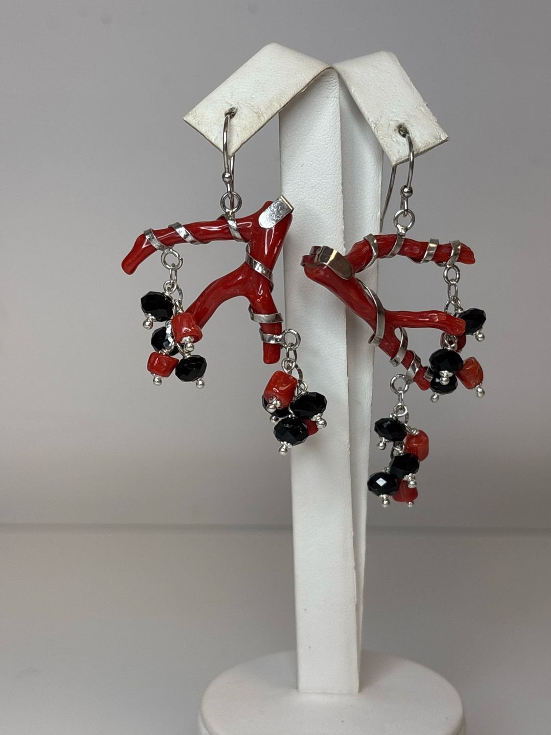 Orecchini  asimmetrici con struttura in argento 925 con corallo Mediterraneo e  agate nere sfaccettate. Lunghi circa 6cm.