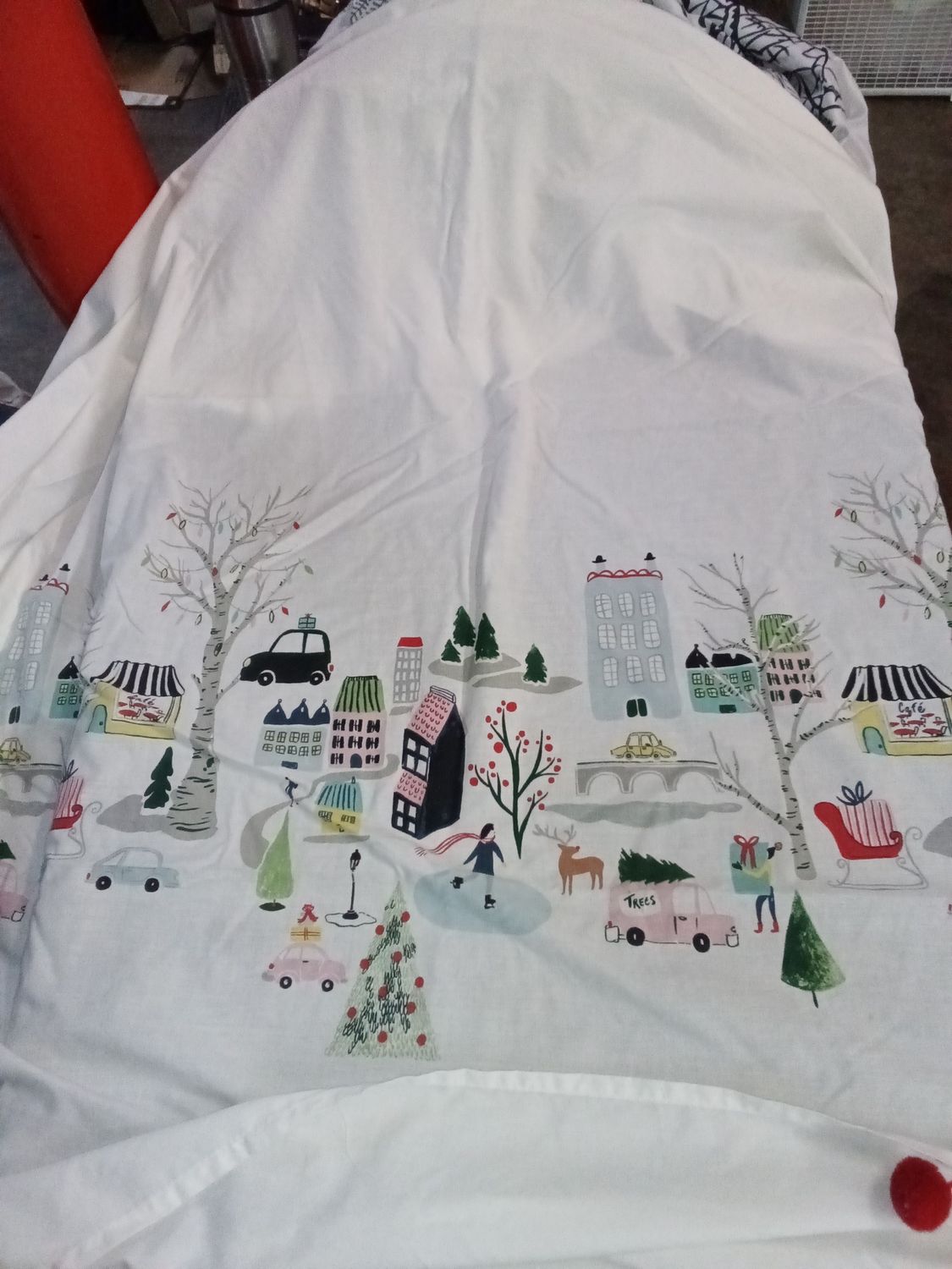 White shower curtain with city design at the bottom for Christmas with red balls at the end