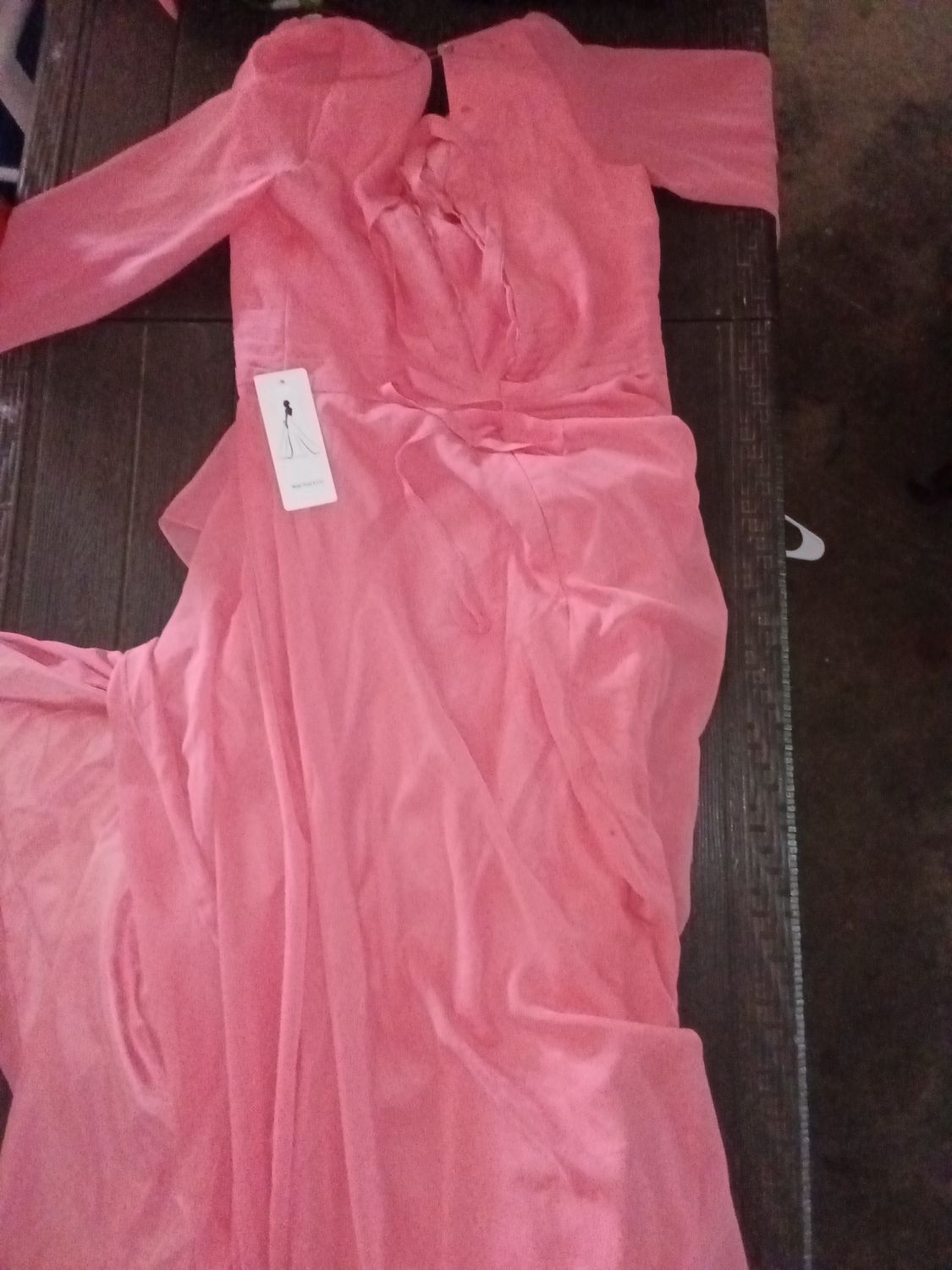 Pink chiffon maxi gown featuring long lantern sleeves, a crossover V-neckline, cascading asymmetrical ruffles along the front skirt, and an open back with a lace-up design.