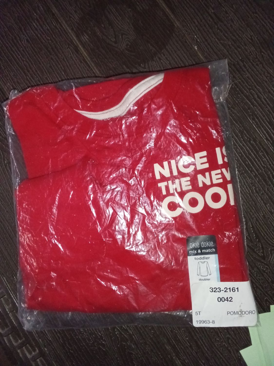 Okie Dokie toddler sweatshirt features white graphic text that reads "NICE IS THE NEW COOL"