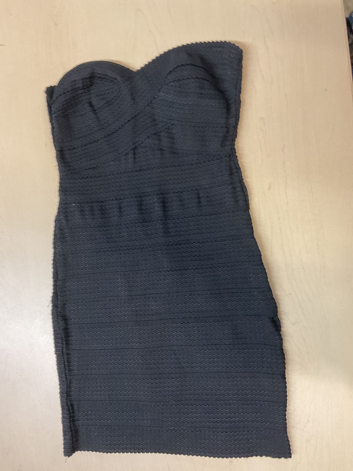 black bodycon tube dress featuring a structured sweetheart/corset-style bust and an all-over crinkle or popcorn-textured knit.