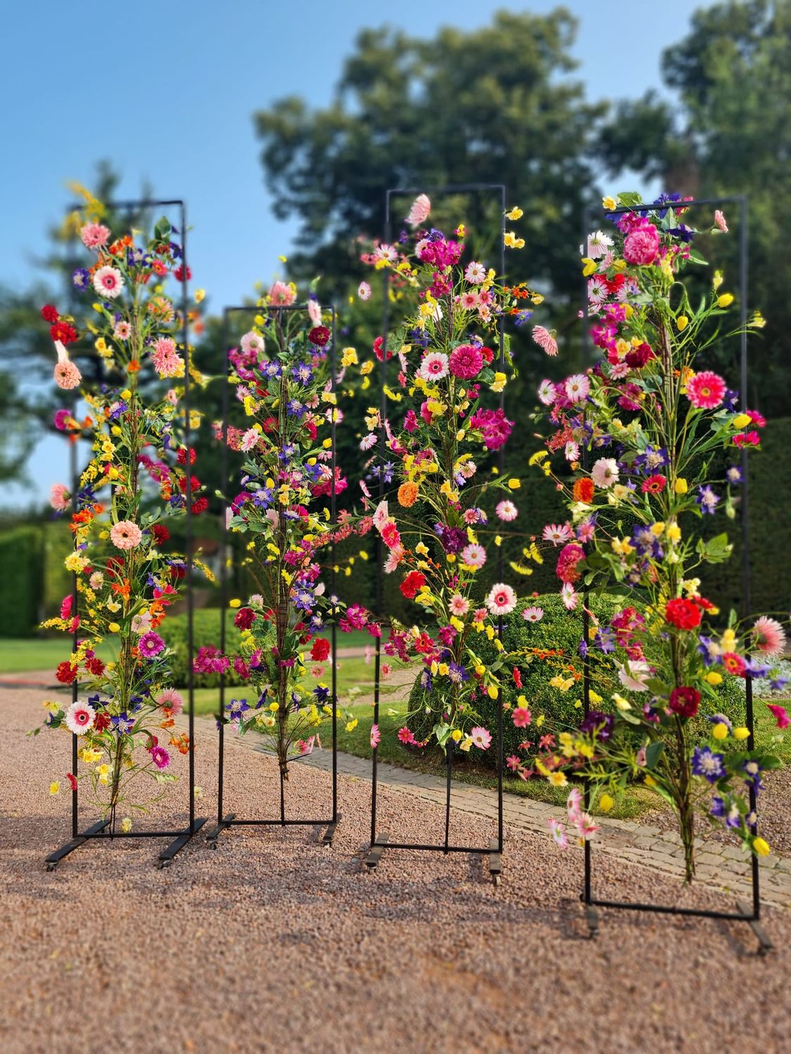 Metalen staander op wielen met kunstbloemen