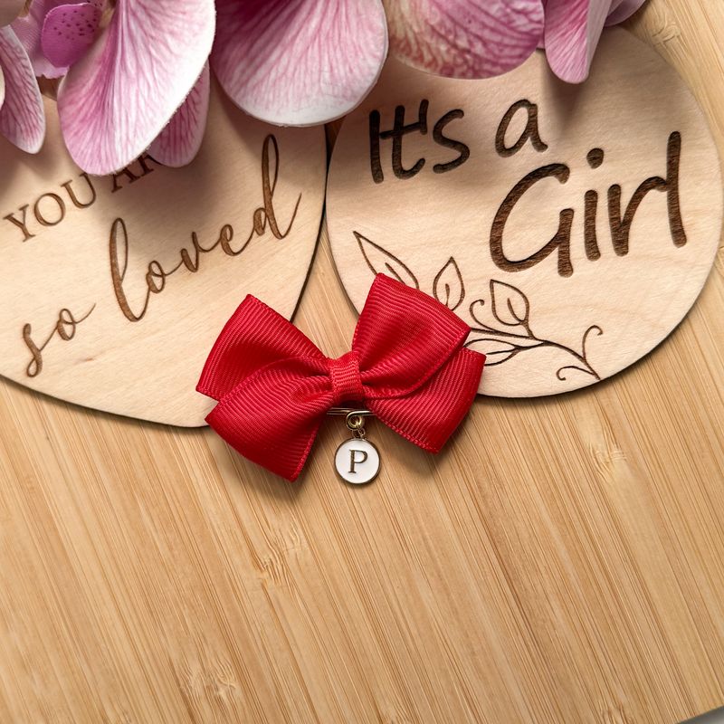 Czerwona kokardka z literką