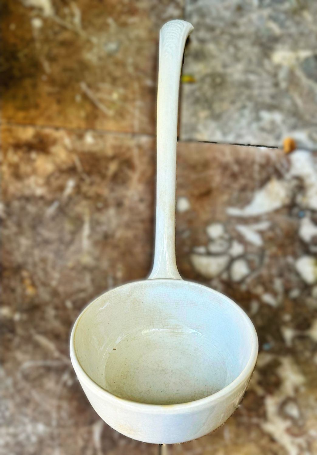 Oude antieke soeplepel of pollepel van wit aardewerk, afkomstig uit een voormalig nonnenklooster Oude antieke soeplepel of pollepel van wit aardewerk, afkomstig uit een voormalig nonnenklooster