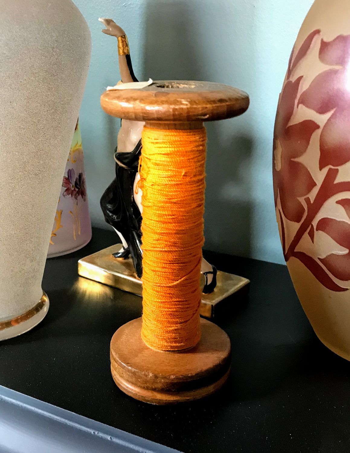 Decoratieve Garenklos met oranje garen spoel in hout Decoratieve Garenklos met oranje garen spoel in hout