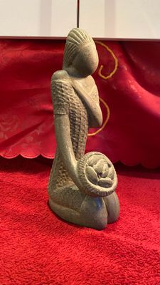 ​Decoratieve stenen sculptuur – Etnische vrouw met broodjesmand ca. 1950