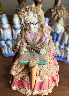 Vintage porseleinen beeldje van kantklossende grootmoeder met sierlijke jurk met kanten details – ca. 1950