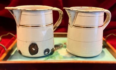 Koppel brocante emaille kannetjes in gebroken wit met gouden biezen afkomstig uit een nonnenklooster – ca. 1900 Koppel brocante emaille kannetjes in gebroken wit met gouden biezen afkomstig uit een nonnenklooster – ca. 1900