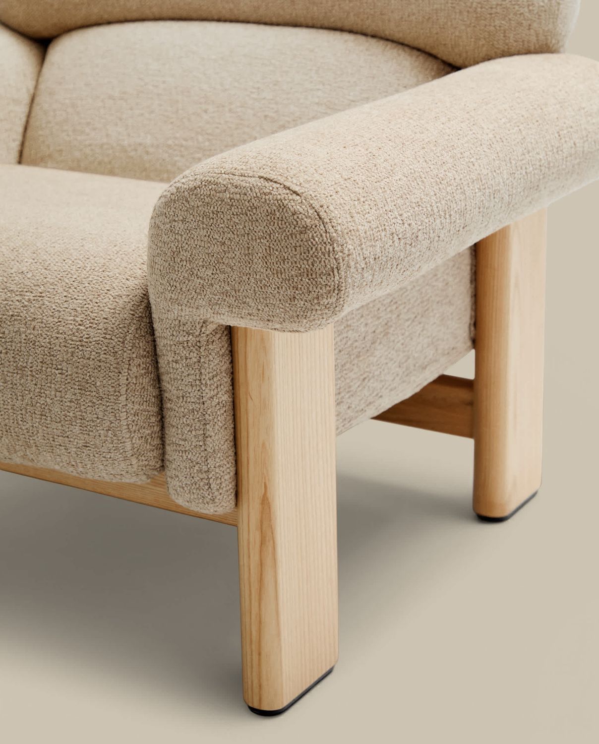 Butaca Nema de chenilla beige y patas de madera maciza de fresno acabado natural FSC 100%