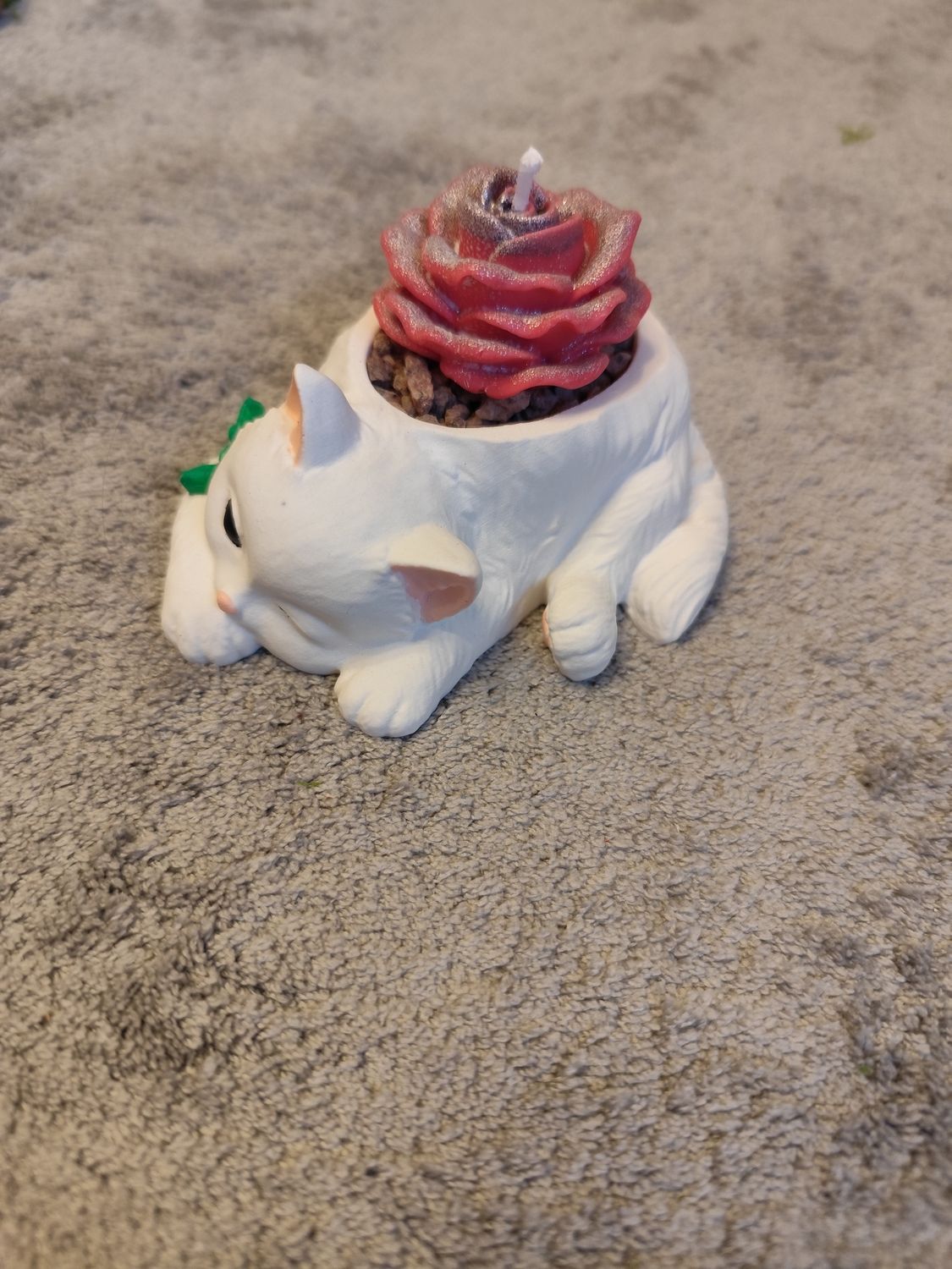 Liegende Katze mit Blume