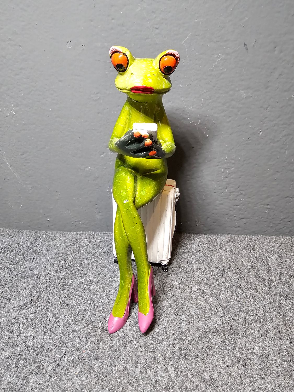 Żaba na białej walizce