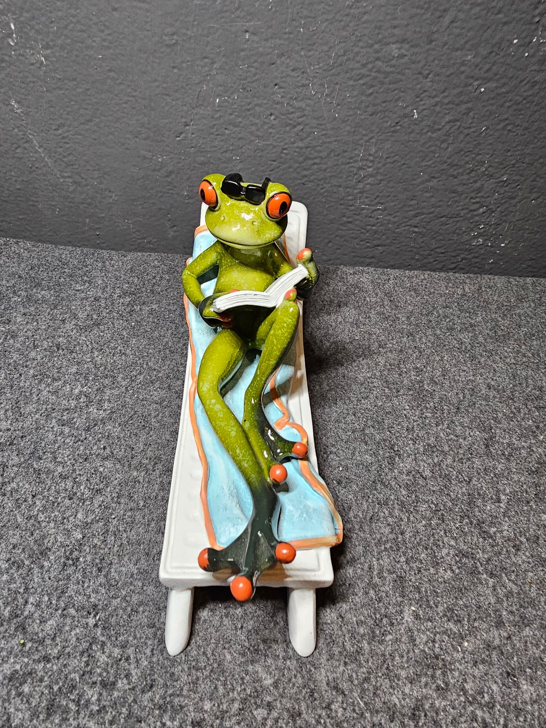 Żaba na leżaku z książką