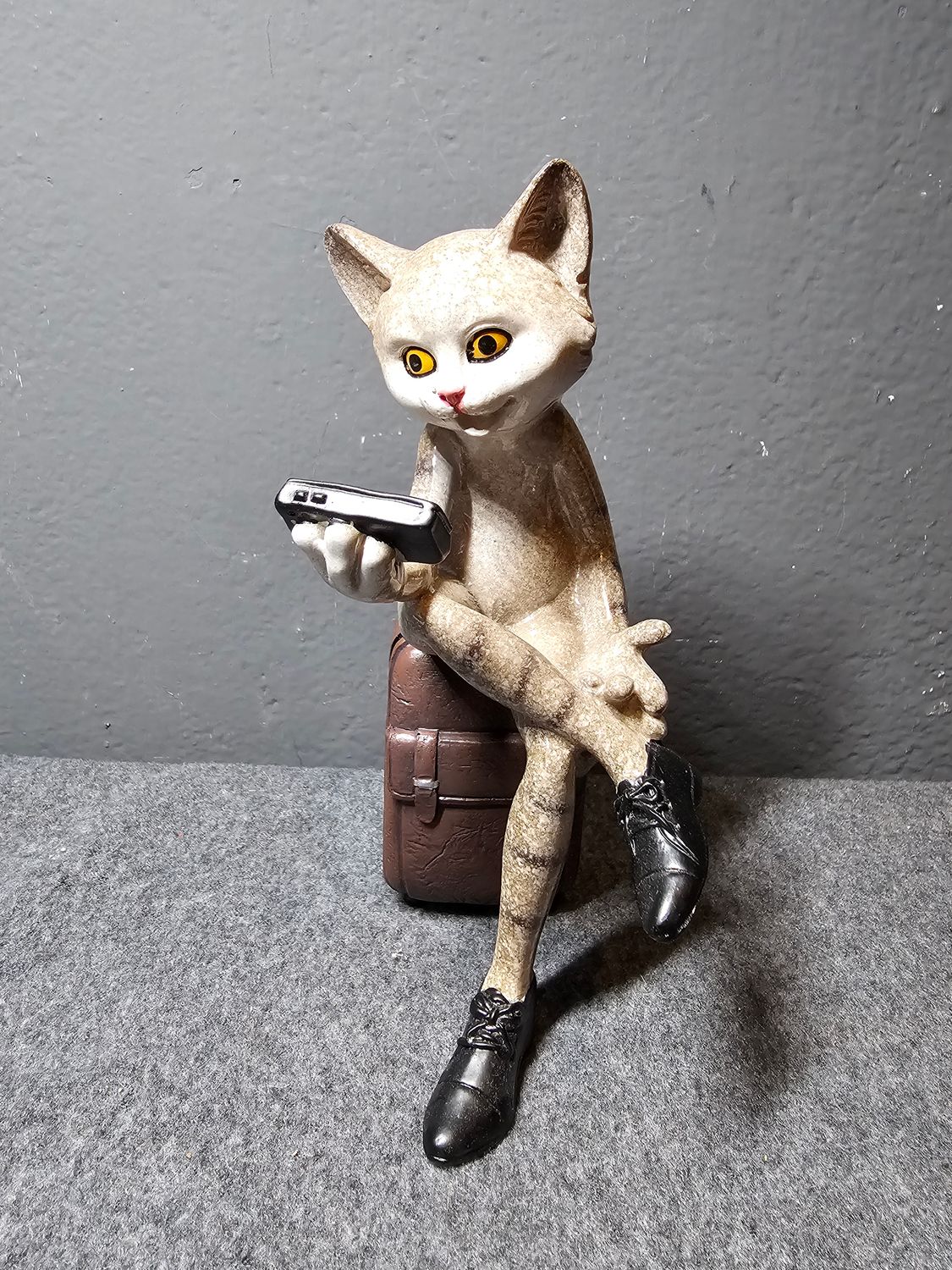 Figurka kot podróżnik siedzący na walizce