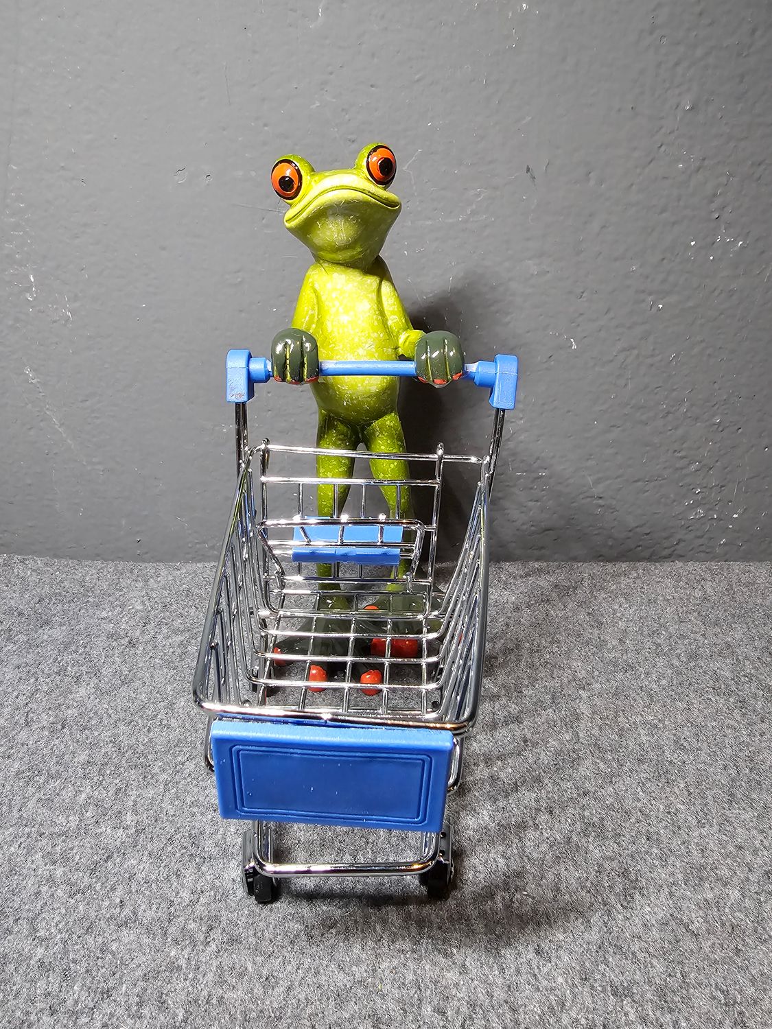 Żaba z koszem niebieskim na zakupy