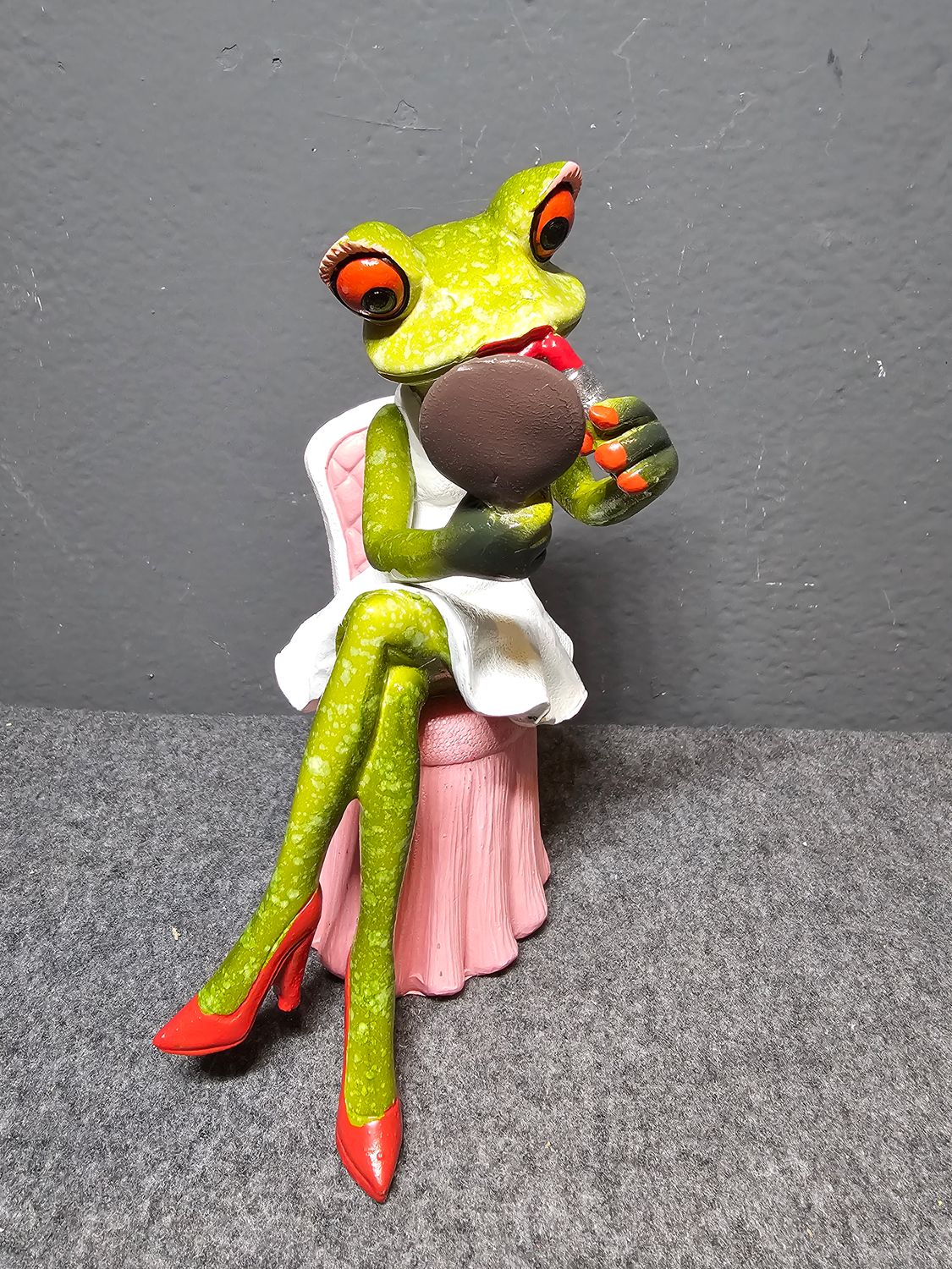 Żaba na fotelu robiąca makijaż