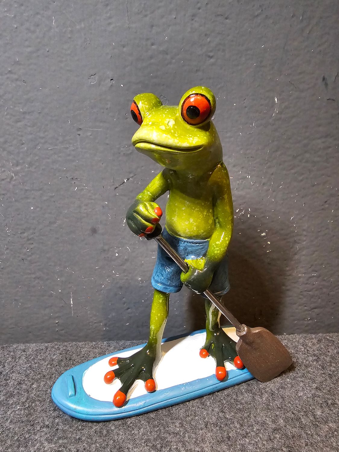 Żaba na desce surfingowej w wiosłem